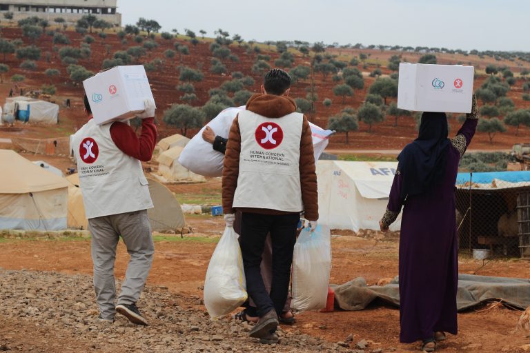 HCI Aid Workers carry winter parcels during the winter months.